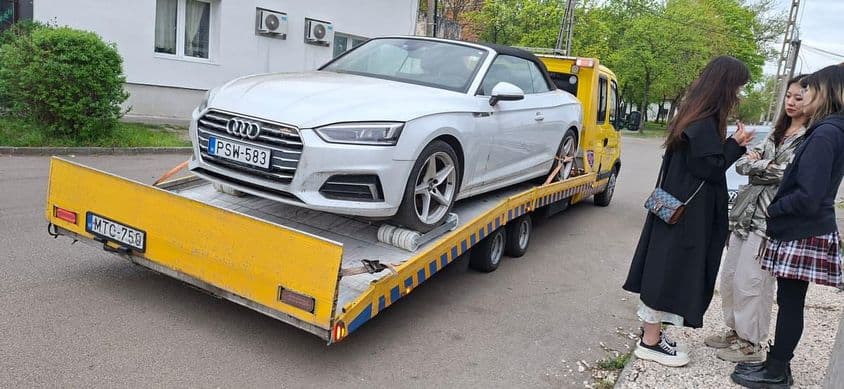 Autómentés után – fehér Audi szállítása tréleren.