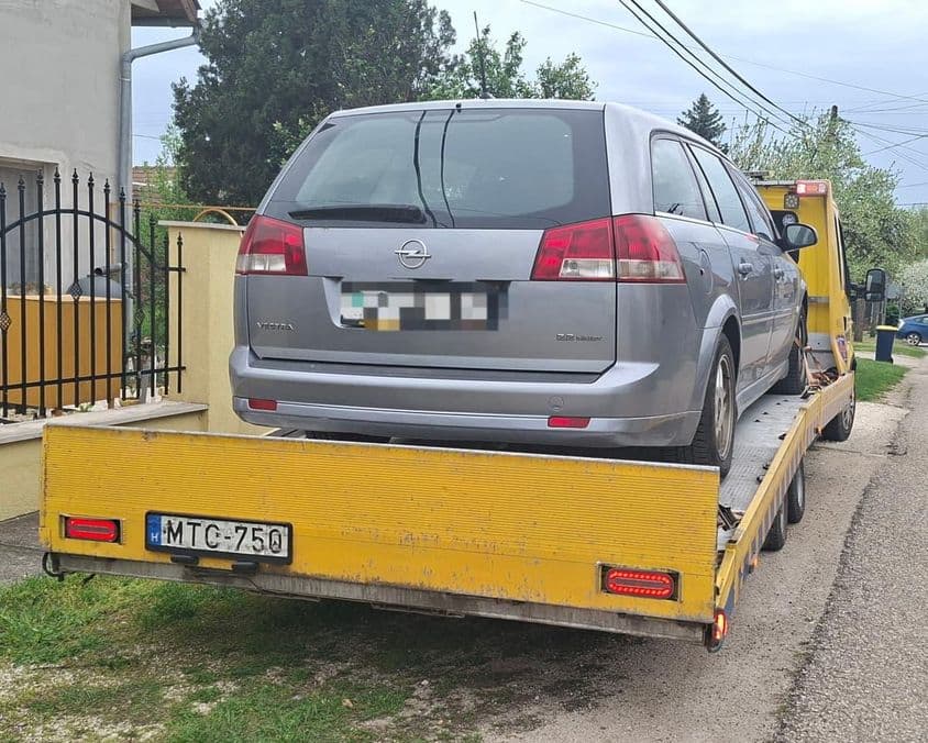 Meghibásodott autó szállítása tréleren.