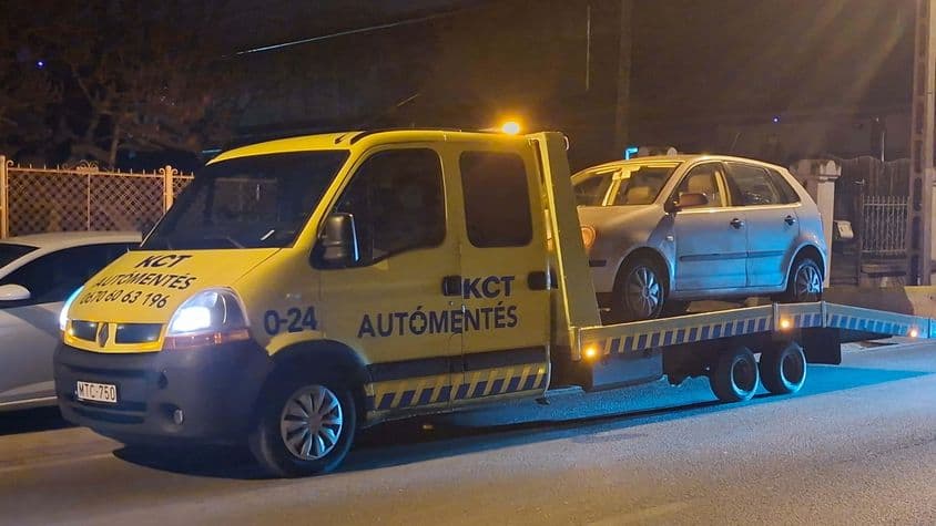 Éjszakai autómentés lakóövezetben sárga trélerrel.