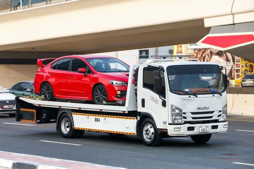 Isuzu Reward vontatókocsi, amely a Subaru WRX piros kocsit szállítja.