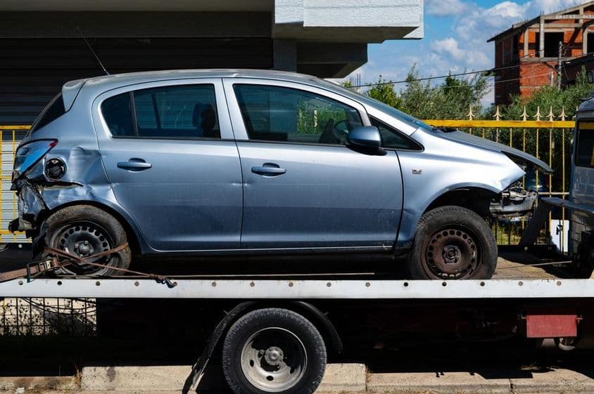 Sérült autó szállítása vontatóval.