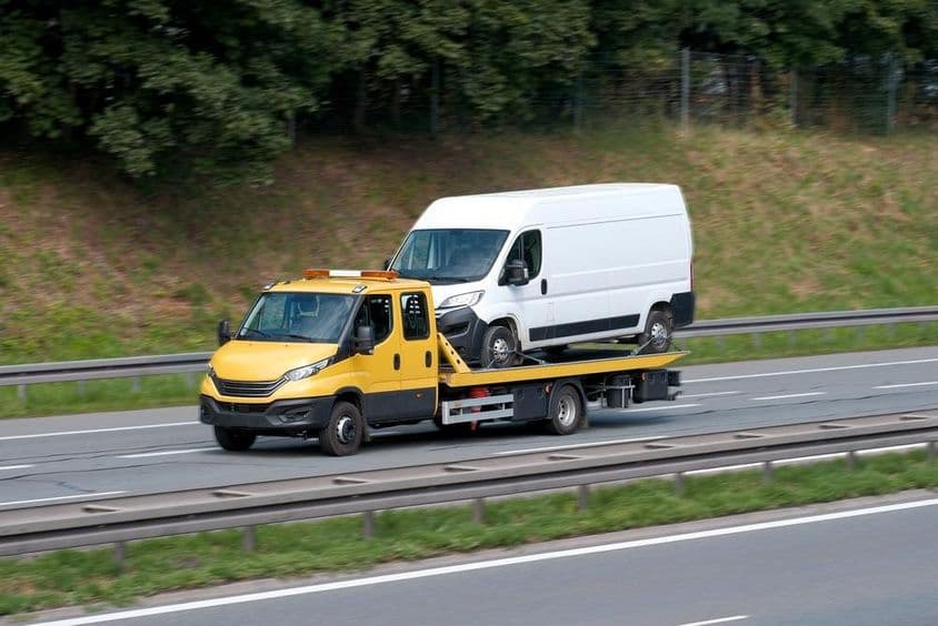Autómentő visz egy teherautót.